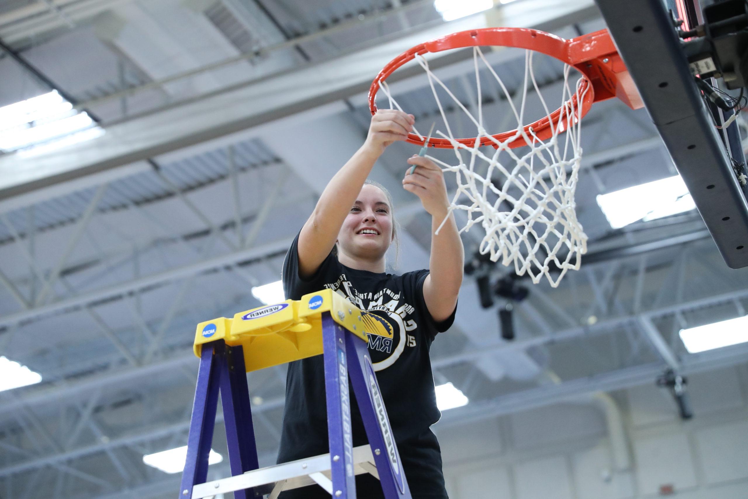 Women's basketball player Brianna Bailey cutting down the nets after MSU Denver's 2022 RMAC championship